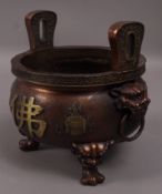 A reproduction Chinese bronzed censor with oni mask and ring handles and three paw feet