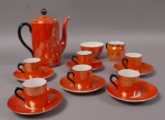A Czechoslovakian orange lustre coffee service comprising coffee pot, sugar and cream, six coffee