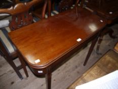 An early 19th century mahogany fold over tea table with deep apron and on square tapered legs