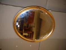 An oval gilt framed bevelled wall mirror