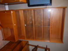 A teak and glazed book case cupboard with sliding doors