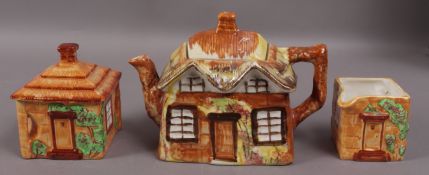 A pottery cottage tea service, comprising tea pot, sugar box and milk jug