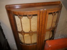 An Art Deco walnut bow fronted two door display cabinet