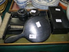 Ebonised dressing table service, including casket tray, clothes brushes, mirror, hair tidy,