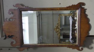A mid 18th century style mahogany wall mirror having a fret cut frame and rectangular glass with