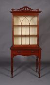 A late Victorian walnut display cabinet, having a fret-cut arched pediment above a tracery glazed