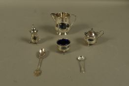 A silver cream jug, Birmingham 1924 together with a three piece cruet of circular outline and cut