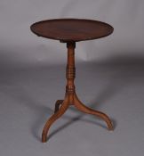 A George IV mahogany tripod table, having a circular dished top and ringed turned column on three
