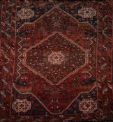 A Caucasian carpet the madder ground woven with a stepped diamond medallion and spandrels, geometric