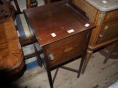 An Edwardian mahogany pot cupboard with three quarter gallery and fan paterae to the door, on square