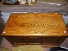 An elm ottoman with triple field panelled front