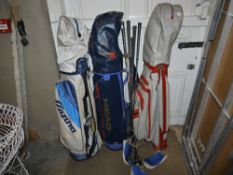 Three sets of golf clubs with caddy bags
