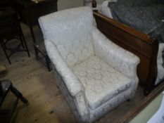 An Edwardian mahogany armchair having a square back upholstered in ivory damask and on short