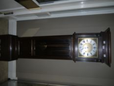 A 1920/30s oak grandmother clock having a square brass dial with silver chaptering and black Roman