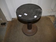 A reproduction industrial stool on cast iron base