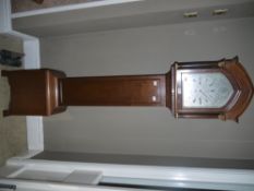 A late Victorian/Edwardian mahogany cased grandmother clock, having an arched hood, silvered dial