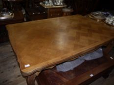A French style oak finish draw leaf dining table, shaped apron and on leaf carved carbriole legs