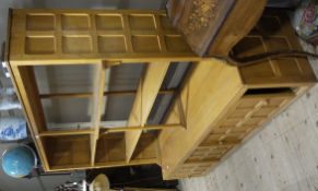 A Yorkshire craftsman made oak cabinet having open shelves with panelled sides, the lower section