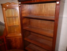 A set of open book shelves, mahogany finished and a corner standing cupboard
