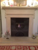 A reproduction cast iron fire grate of early Victorian style together with a stone fire surround