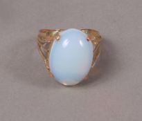 A dress ring in 14ct rose gold, c.1950 claw set with an oval opalescent paste, with Egyptian