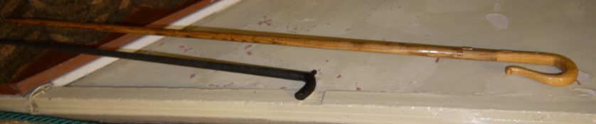 A carved ebonised wood walking cane, together with a shepherds crook style walking stick
