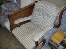 A Victorian oak framed armchair having an upholstered buttoned back and arms, turned uprights and