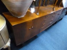 A LARGE TEAK BOW FRONTED SIDEBOARD, with four central drawers flanked by twin cupboards, approximate
