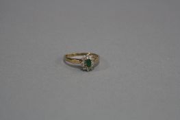 A MODERN 9CT GOLD DIAMOND AND EMERALD OVAL CLUSTER RING, estimated total diamond weight 0.12ct, ring