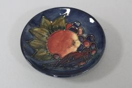 A MOORCROFT POTTERY PIN DISH, tube lined decorated with Finch and Fruit, impressed marks, diameter
