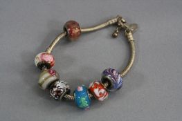 A SILVER CHARM BRACELET, with various beads