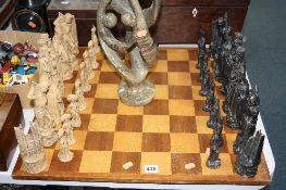 A LARGE CHESS SET AND BOARD, together with a large soapstone figure group