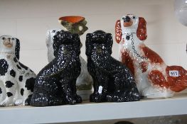 FIVE VICTORIAN STAFFORDSHIRE POTTERY SEATED SPANIEL CHIMNEY ORNAMENTS, including a pair of glazed