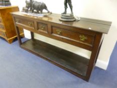 A GEORGIAN OAK THREE DRAWER DRESSER BASE, the small central drawer flanked by larger drawers, on