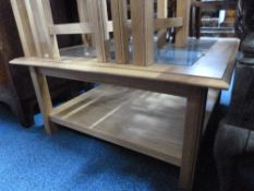 A MODERN LIGHT OAK COFFEE TABLE, with glass inset top and undershelf