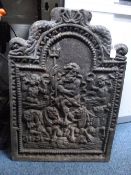 A CAST IRON FIRE BACK, with central figural detail