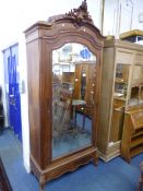 A CARVED HARDWOOD ARMOIRE, with bevelled mirror door and lower drawer, approximate size width