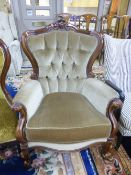 A VICTORIAN STYLE BUTTON BACK ARMCHAIR, with fawn upholstery and carved frame