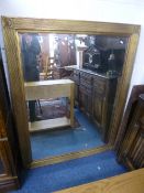 A LARGE MODERN GILT FRAMED WALL MIRROR, approximate size 140cm x 109cm