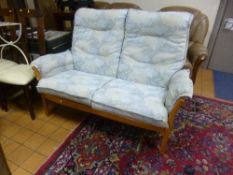 AN 'ERCOL' TWO SEATER SOFA, with pale blue floral upholstery