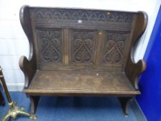 A CARVED OAK HALL SETTLE, approximate size width 127cm x depth 46cm x height 121cm, inscribed