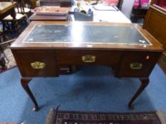 A MAHOGANY THREE DRAWER DESK, with tooled leather inlay top on tall cabriole supports, approximate