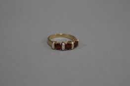 A MODERN GARNET AND DIAMOND 9CT GOLD DRESS RING, total diamond weight approximately 0.04ct, ring