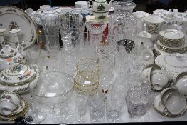 A COLLECTION OF CUT GLASS VASES, DRINKING GLASSES, JUG WITH PLATED STRAINER LID, CANDLESTICKS, etc