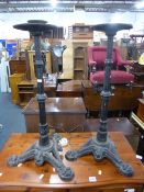 A PAIR OF BLACK PAINTED CAST IRON STANDS, with tripod bases