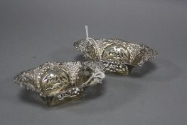A PAIR OF EDWARDIAN SILVER BON BON DISHES, of shaped rectangular form, embossed and pierced