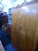 A WALNUT FOUR PIECE BEDROOM SUITE, comprising a two door wardrobe, chest of five long drawers, a