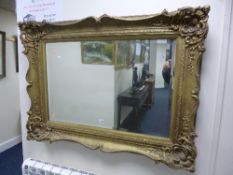 A HEAVY GILT FRAMED WALL MIRROR, approximate size 119cm x 87cm