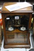 AN OAK SMOKER'S CABINET, with front opening glazed door, with ceramic tobacco jar (re-glued lid) and