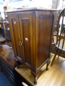 AN OAK TWO DOOR CABINET, with shelves